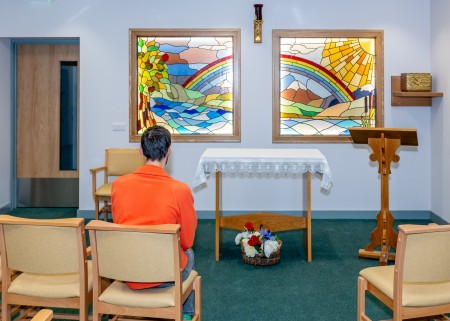 Volunteer sitting in chapel facing altar